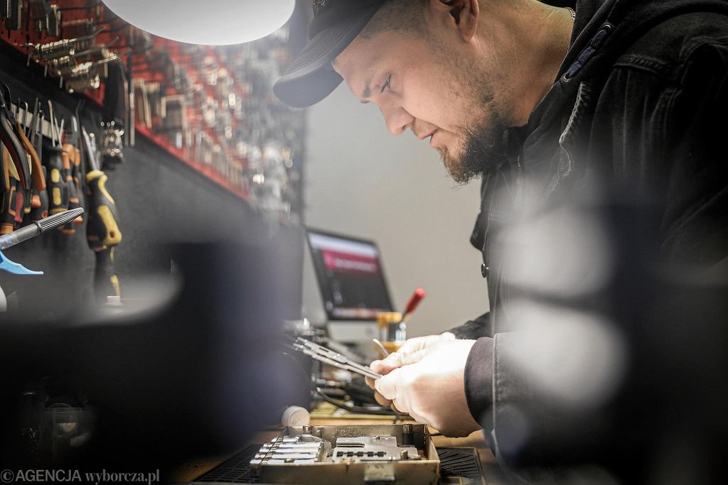 Technik dorabiający klucz na maszynie w warsztacie