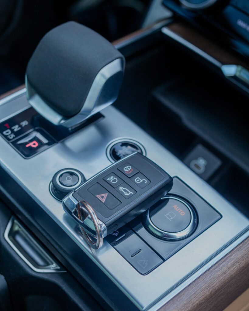 Detailed view of a luxury car's gear shift and key fob highlighting modern automotive design.