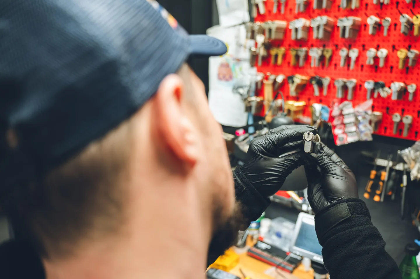 Technik Włamywacz przy zamku na tle ekspozycji kluczy